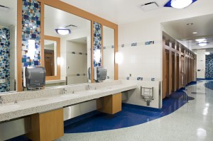 At YVR, travellers find clean, modern washrooms in which to freshen up during their journeys. The washroom walls in C-Pier of the Domestic Terminal are covered in shades of blue, red, and yellow mosaic tiles. Wave-shaped blue flooring winds down the curved corridor, leading guests to their choice of bathroom stalls.